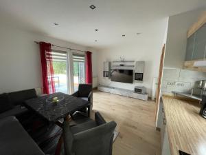 a living room with a couch and a table and a television at Haus Sonnenschein in Koserow