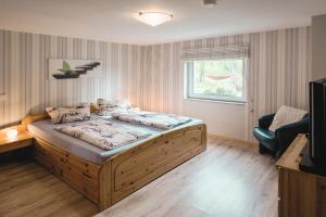 ein Schlafzimmer mit einem Bett, einem Stuhl und einem Fenster in der Unterkunft WEINQUARTIER Kalter Hügel 70 qm Garten Lagerfeuer Pool Terrasse Parkplatz in Naumburg