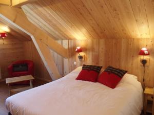 ネヴァッシュにあるLe Belletyのベッドルーム1室(赤い枕2つ付きのベッド1台付)