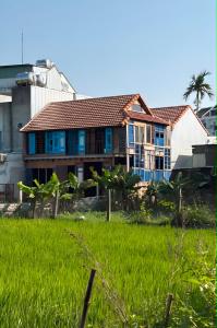 a house in the middle of a field of grass at Wooden chill house in Hoi An