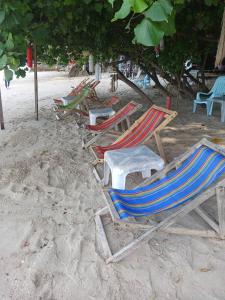 a group of chairs and tables on a beach at Changbar Bungalow in Ban Ao Sapparot