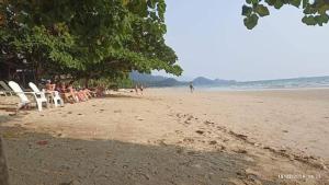 a group of people sitting in chairs on a beach at Changbar Bungalow in Ban Ao Sapparot