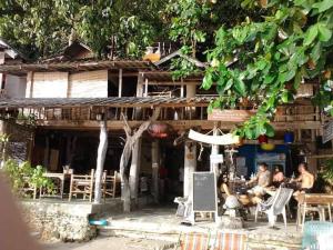 a group of people sitting outside of a building at Changbar Bungalow in Ban Ao Sapparot