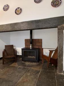 a living room with a fireplace and two plates on the wall at Casa Velha in Mourão