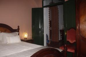 a bedroom with a bed and a chair and a window at Casa Velha in Mourão +37 photos