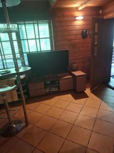 a living room with a large flat screen tv at Forest House in Pašvinės