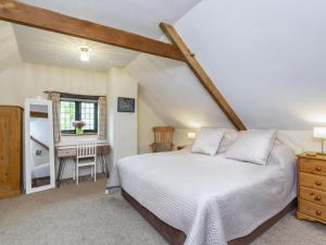 a bedroom with a white bed and a desk at Apartment The Appleloft suite by Interhome in Holsworthy