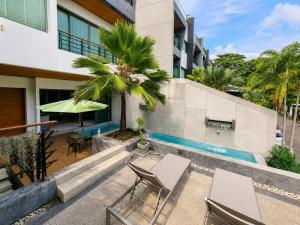 a patio with two chairs and a palm tree next to a building at Luxury Villa with Panoramic Seaview, Private Pool in Ban Saiyuan (1)