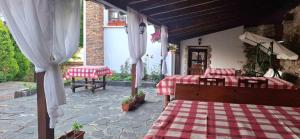 a patio with two tables and a red and white checkered blanket at Guest House Popov in Marchevo
