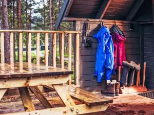 a porch of a cabin with a bench and clothes at Chalet Beekeepers Bothy by Interhome in Coldstone