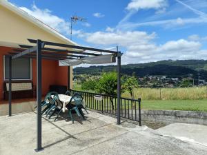 a patio with a table and chairs under a canopy at Casa Castro in A Estrada