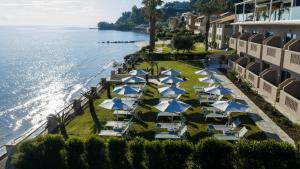 Luftaufnahme eines Ferienresorts mit blauen und weißen Sonnenschirmen in der Unterkunft Anemona Beach Hotel in Argassi