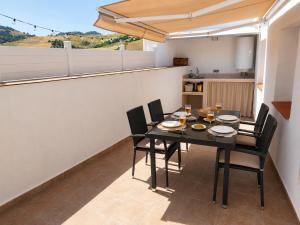 a dining room with a black table and chairs at La Casita de Isabel, Near Ronda, Sierra de Grazalema in Montecorto