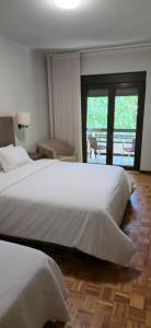 ein Hotelzimmer mit zwei Betten und Balkon in der Unterkunft Hotel Ribadouro in Alijó
