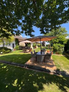 a table and chairs under an umbrella in a yard at Dworek in Szonowice
