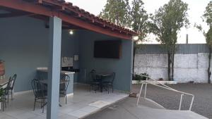 a patio with a table and chairs and a tv at Hotel Vale do Sol in Votuporanga