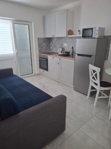 a kitchen with a bed and a refrigerator and a table at Apartmani T'n'T in Pag