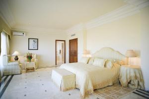 a bedroom with a large bed and a chair at Mehari Tabarka in Tabarka