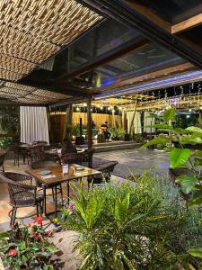 an outdoor patio with tables and chairs and plants at Gaia Hotelaria in Teresópolis