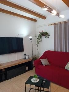 a living room with a red couch and a flat screen tv at Matteo in Supetarska Draga