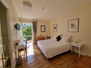 a bedroom with a white bed and a balcony at Le Rodin Bazas in Bazas +38 photos