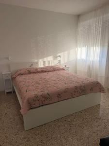 a bedroom with a bed with a pink comforter at Binario1 Lake View in Lierna
