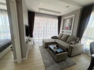 a living room with a couch and a table at The Patio Bangsaen Cozy Condo in Chon Buri