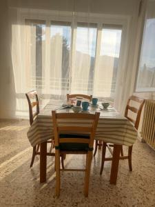 a dining room table and chairs with a view of the city at Binario1 Lake View in Lierna