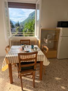 a table and chairs in a kitchen with a window at Binario1 Lake View in Lierna