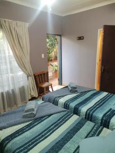 two beds sitting next to each other in a bedroom at My Serenity Guesthouse in Mokopane