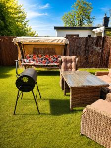 a grill in a yard with a table and a bed at Apartament Biała Flaga Podwórko, Grill, Rowery in Charzykowy