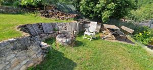 a garden with a chair and a stone wall at Veža na vlásku in Háj