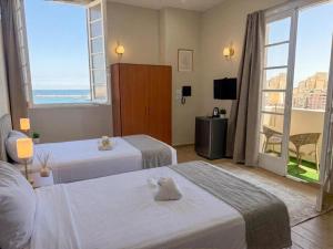 a hotel room with two beds and a large window at New Hyde Park House Hotel in Alexandria +4 photos