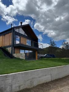 a house on a hill with a car in the background at Vamas Villa in Dobroselica