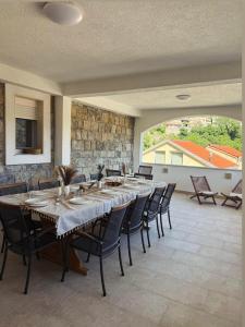 a large dining room with a long table and chairs at Villa with stunning Mountain Views and Authentic Croatian Stone House near Split and Sea in Žrnovnica