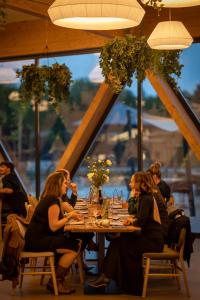 a group of people sitting at a table in a restaurant at The Spot Resort in Poljanski Lug