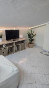 a living room with a flat screen tv on a table at Vilas do Mar - Studio in Carvoeiro