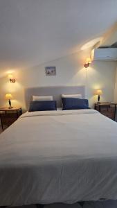 a bedroom with a large white bed with blue pillows at Vilas do Mar - Studio in Carvoeiro +20 photos