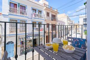 a table with bowls of food and drinks on a balcony at Apartamentos Nerjaluna in Nerja