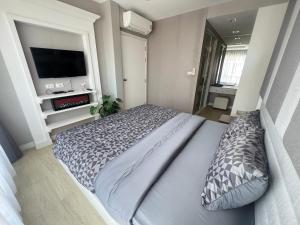 a bedroom with a large bed and a television at The Patio Bangsaen Cozy Condo in Chon Buri +14 photos