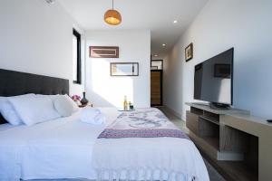 a bedroom with a large bed with a flat screen tv at Casa Arte by Vibrant in Vichayito