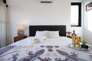 a bedroom with a bed with a tray of wine bottles at Casa Arte by Vibrant in Vichayito +93 photos