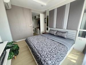 a bedroom with a large bed in a room at The Patio Bangsaen Cozy Condo in Chon Buri