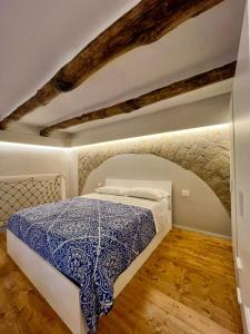 a bedroom with a bed with a blue and white bedspread at Addor 'e Mare in Bacoli