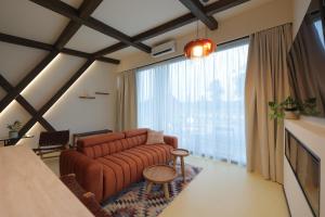 a living room with a couch and a large window at The Spot Resort in Poljanski Lug