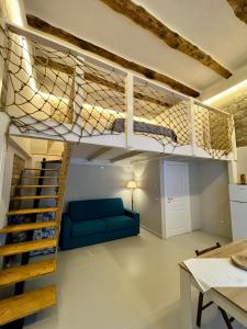a loft bed in a living room with a blue couch at Addor 'e Mare in Bacoli