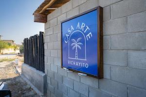 a sign on the side of a building with palm trees at Casa Arte by Vibrant in Vichayito