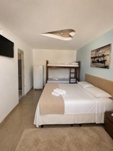 a bedroom with a bed and a refrigerator at Pousada Recanto Paradise in Porto De Galinhas