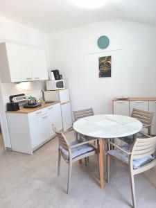 a kitchen with a table and some chairs and a table and a kitchen at Slanraj apartman in Jadrtovac