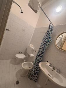 a bathroom with a toilet and a sink and a mirror at Campus Baia Serena in Bellaria-Igea Marina